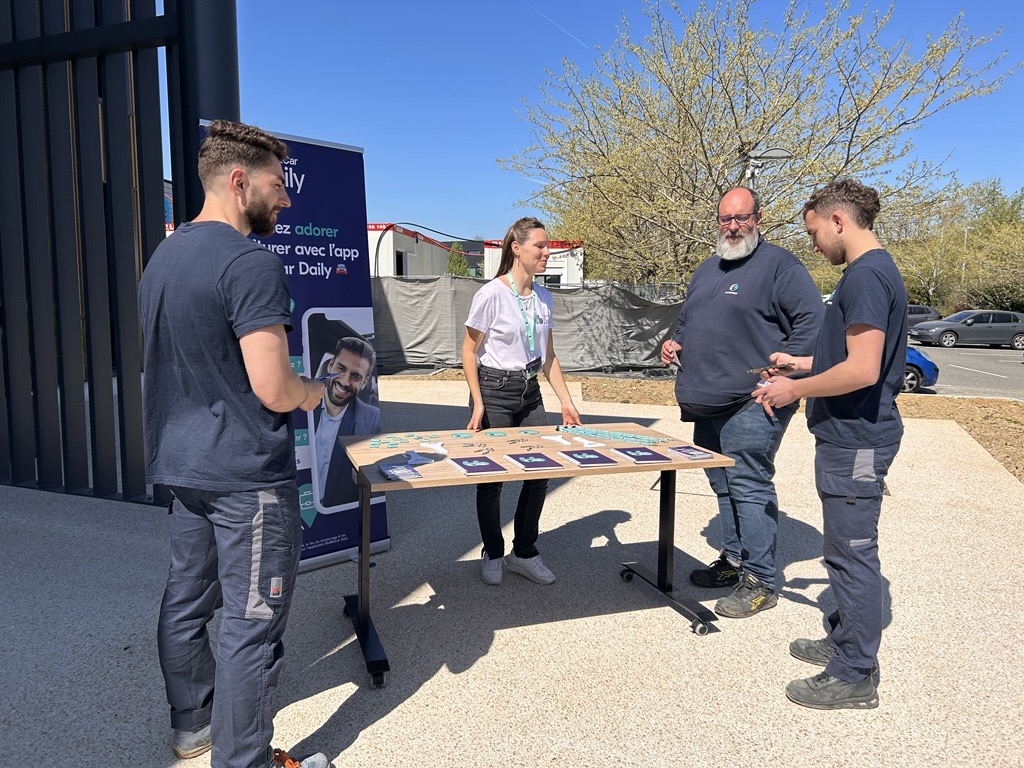 Des collaborateurs d'Air Support découvrent l'application de covoiturage BlaBlaCar Daily lors d'un stand de sensibilisation dans la zone d'activité du Roulage.